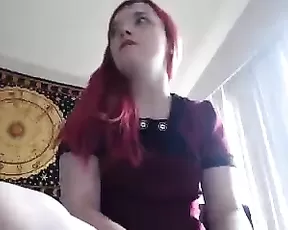 A small breasted red head is getting off on camera