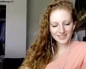 Redhead is pushing a dildo in