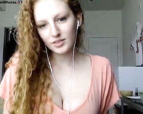 Redhead is pushing a dildo in